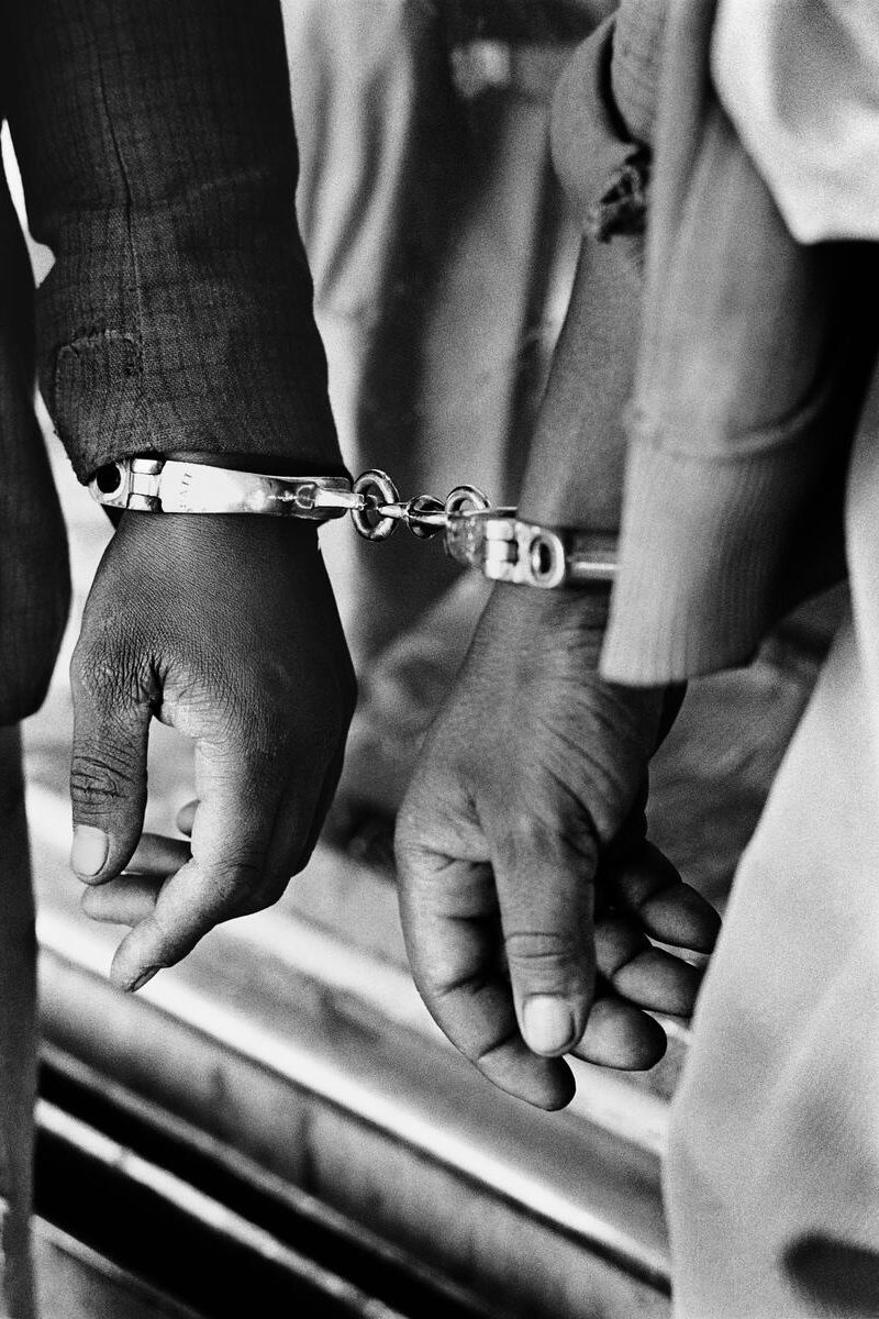 SOUTH AFRICA. 1960s. Handcuffed blacks were arrested for being in a white area illegally.
