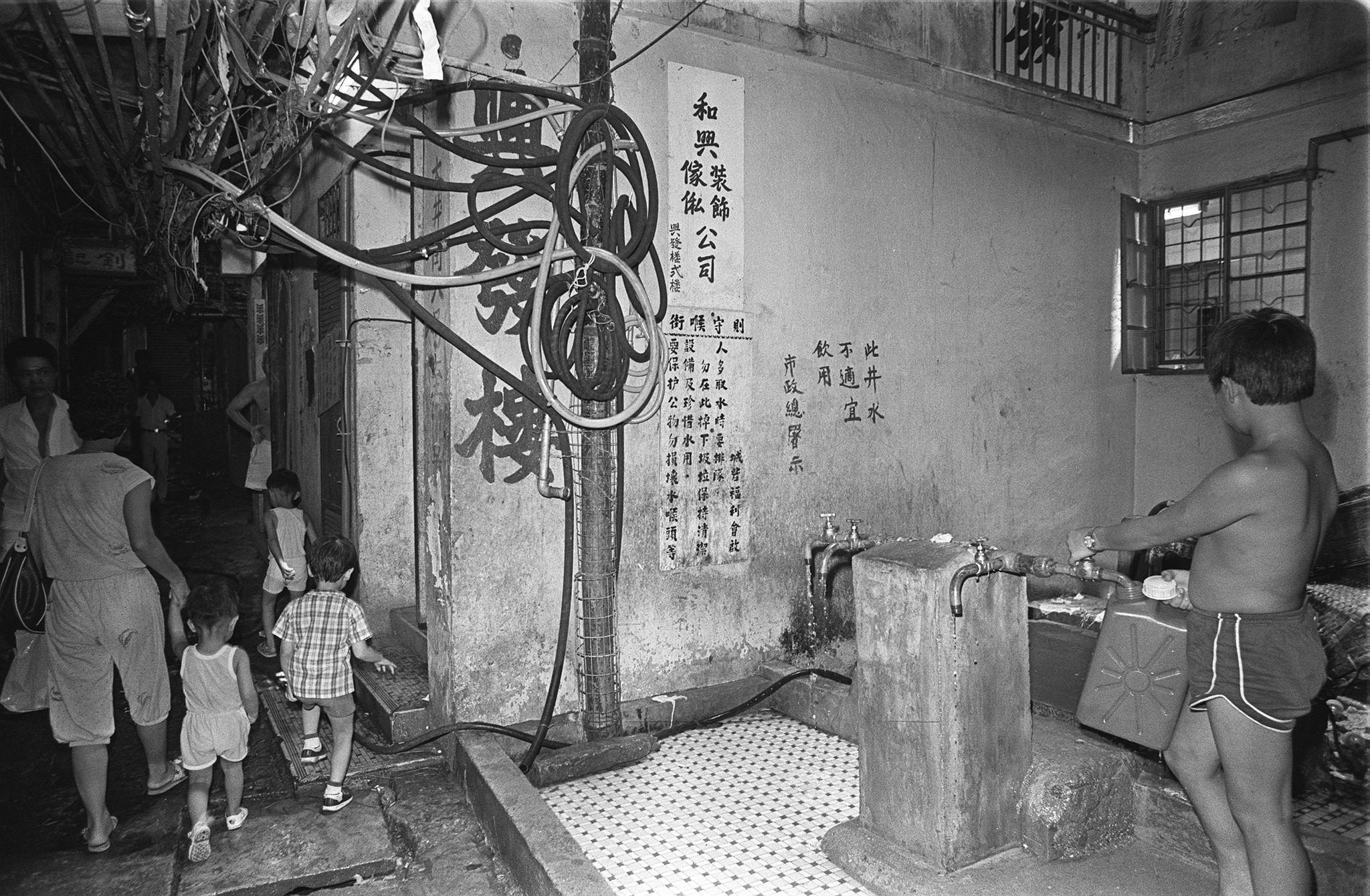 The Kowloon Walled City is a no man's land and not subject to Chinese and British administration. With its labyrinth of criss-cross lanes and blind alleys, it  is also an eyesore. Electricity cables can be seen dangling dangerously from buildings and water supply is a major cause of complaint for its estimated 30,000 residents. There are only four standpipes in the area and residents want two more to be installed. SCMP/ Chan Kiu