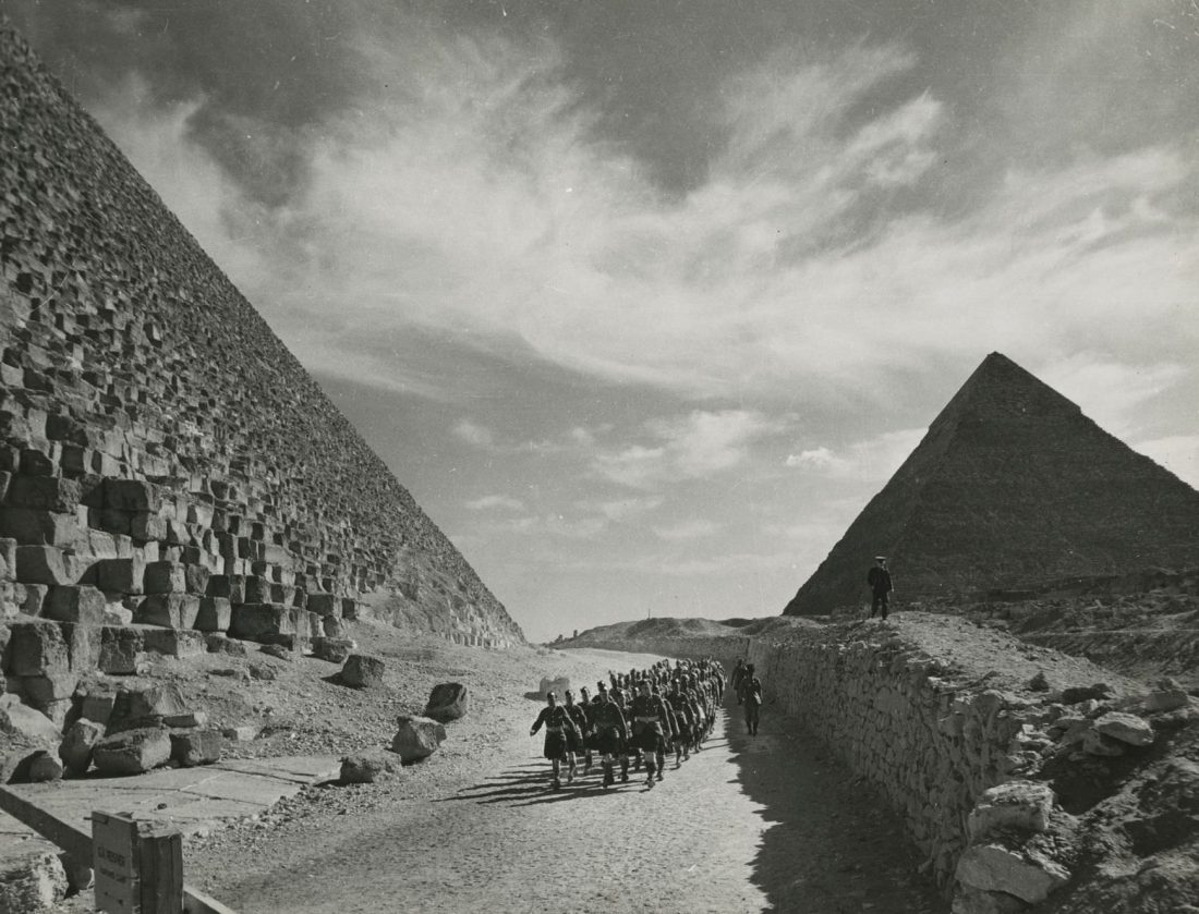 Indian and scottish solders march along the Giza piramides